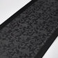 Black embossed patterned mat on a white background