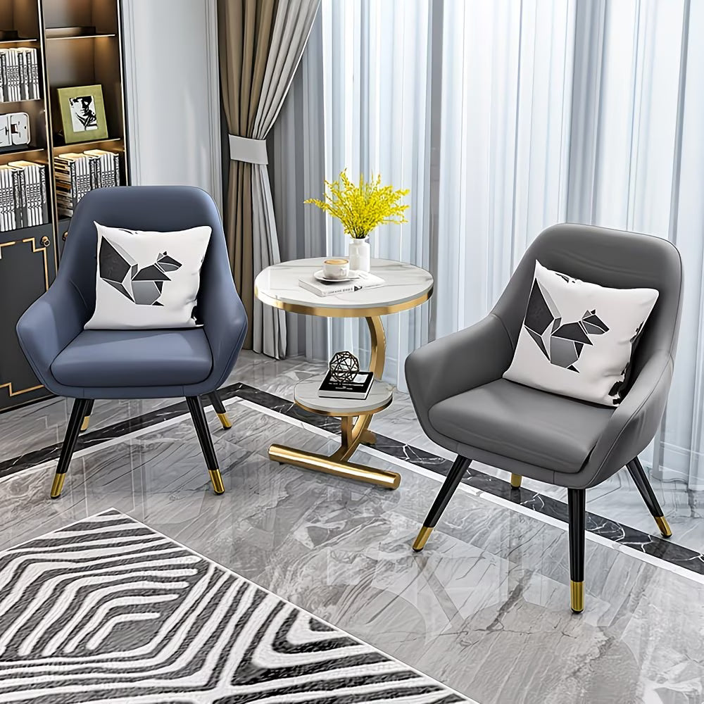 Modern living room with two armchairs, a small table, and decorative elements.