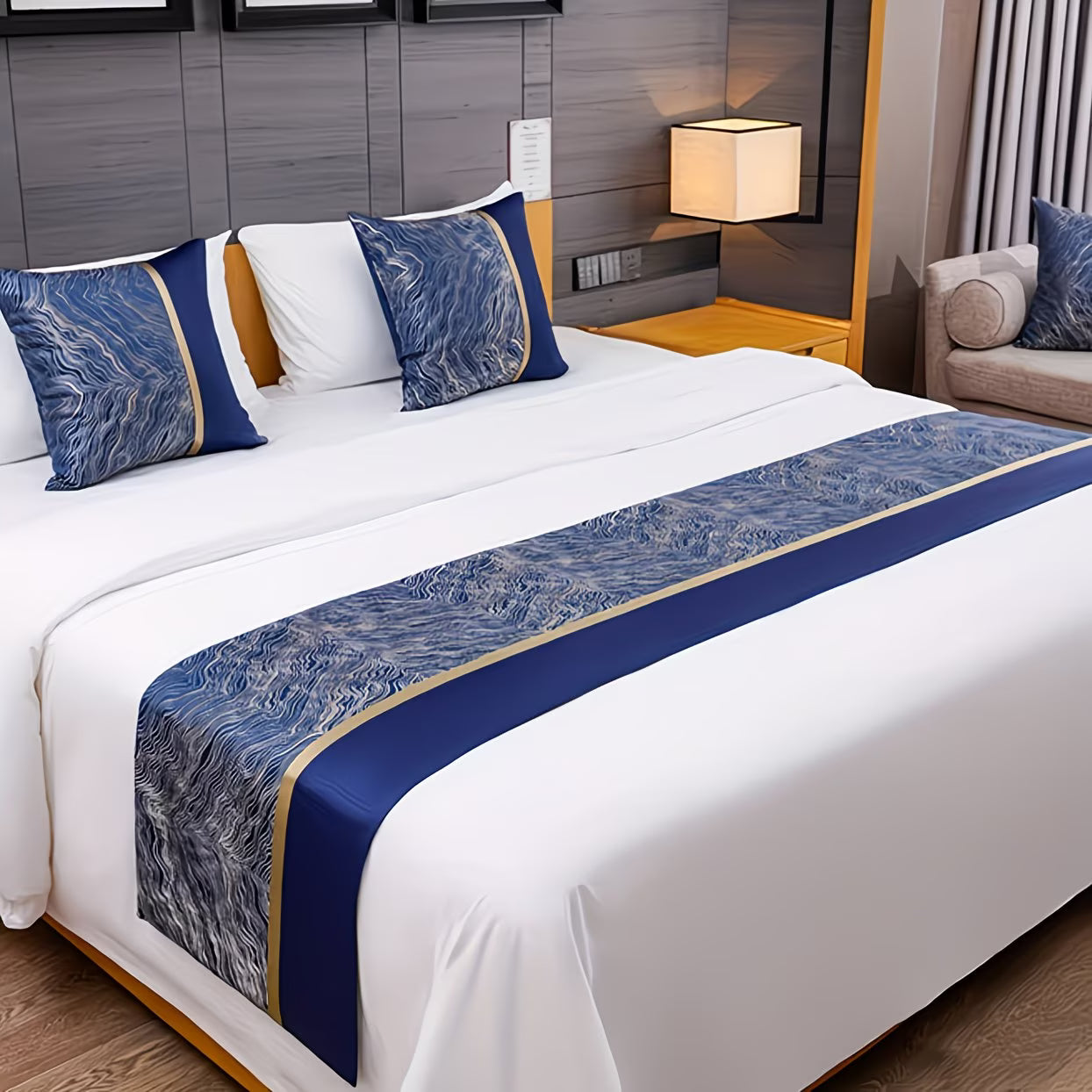 Bedroom with a neatly made bed featuring blue and white decorative pillows and a runner.