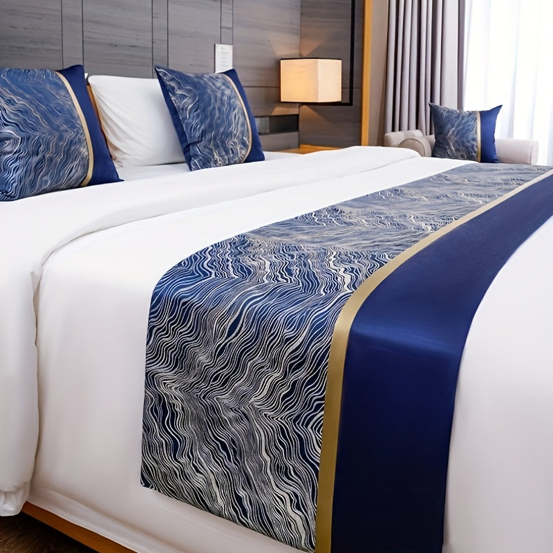 Bed with blue and white patterned bed runner and pillows in a bedroom setting.