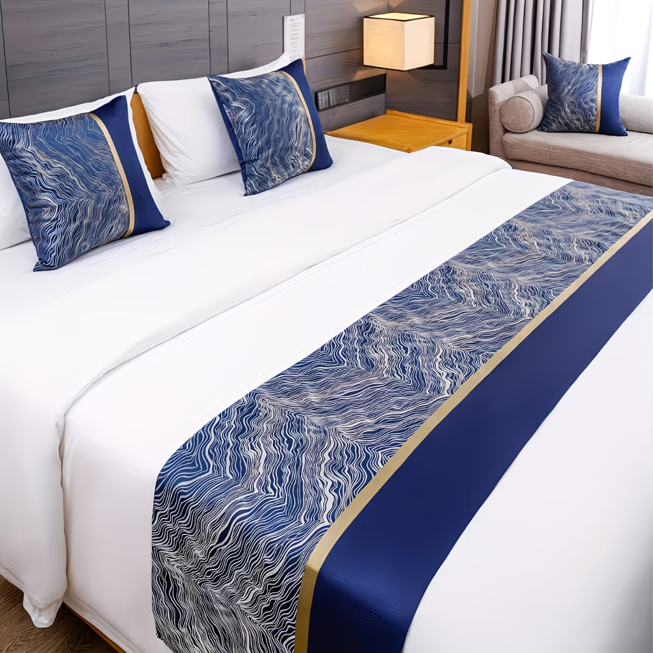 Bed with blue and gold patterned bed runner and pillows in a bedroom setting.