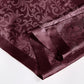 Mauve satin fabric with a decorative pattern and bow on a white background