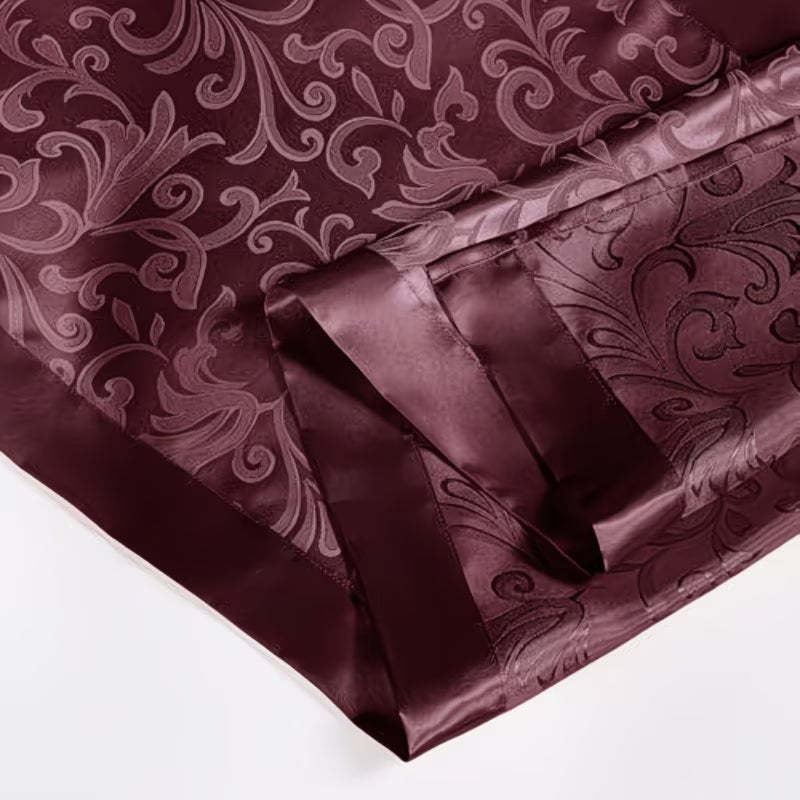 Mauve satin fabric with a decorative pattern and bow on a white background