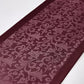 Maroon fabric with intricate floral pattern on a white background