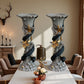 Two decorative candle holders on a table with a warm interior setting.