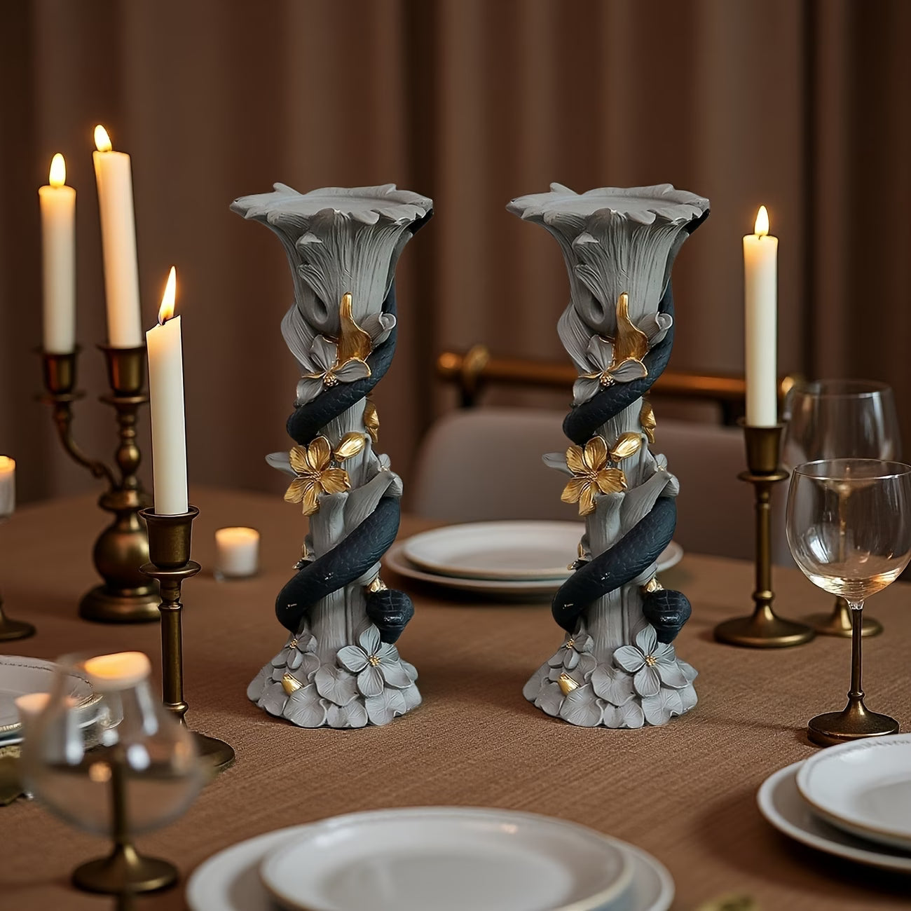 Decorative candle holders on a table with candles and glasses.