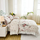Bedroom with floral bedding, white nightstand, and large windows.