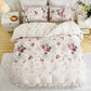 Floral patterned bedding set on a bed in a bedroom setting.