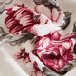 Close-up of floral fabric with red and pink flowers on a white background