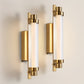Gold wall sconces with clear glass on a neutral background