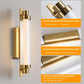 Gold wall sconce with crystal-like glass rods on a gray background