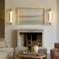 Living room with a fireplace, wall sconces, and decorative items.
