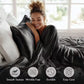Woman wrapped in a black satin blanket with product features displayed.
