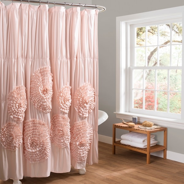 Pink floral shower curtain in a bathroom with a window and wooden shelf.