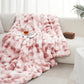 Pink fluffy blanket draped over a sofa with a glass of wine on a small table.