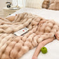 Person lying on a bed under a fluffy beige blanket with a green apple and magazine.