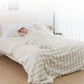 Person lying in bed under a fluffy white comforter in a bright bedroom.