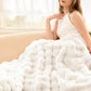 Woman sitting on a couch with a white textured blanket draped over her