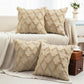 Four beige textured pillows on a sofa in a living room setting.