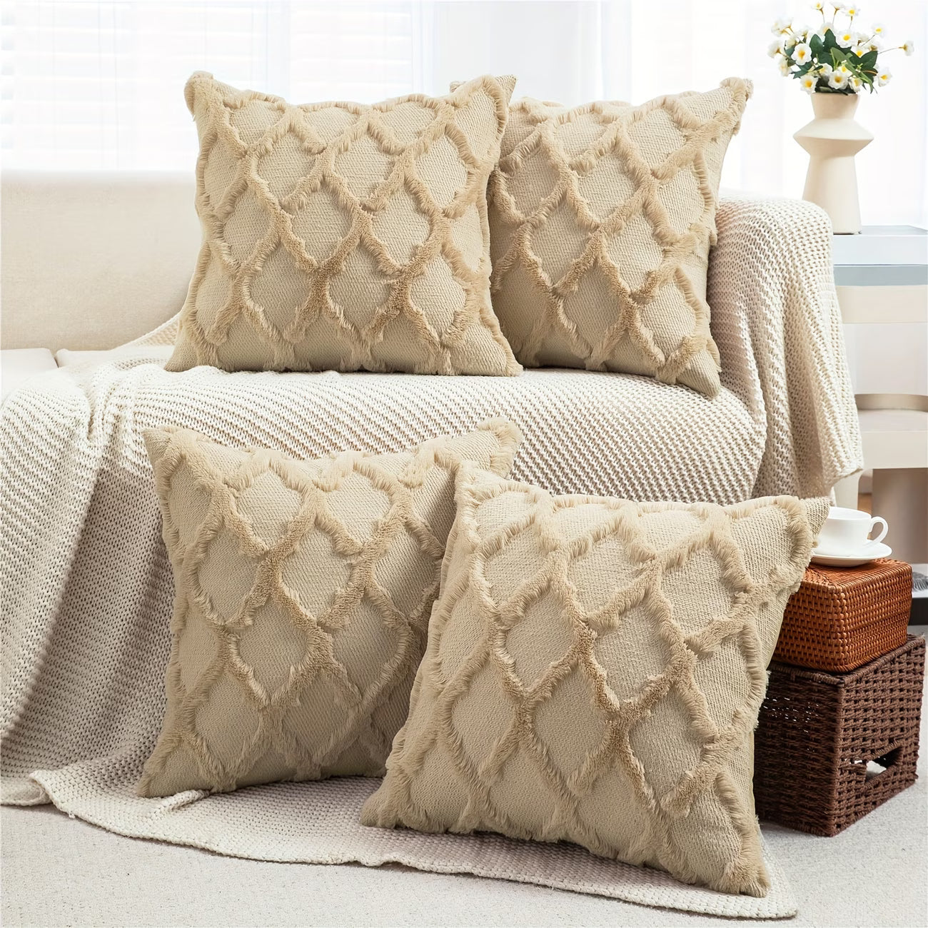 Four beige textured pillows on a sofa in a living room setting.