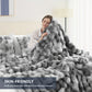 Person wrapped in a fluffy gray blanket in a cozy bedroom setting