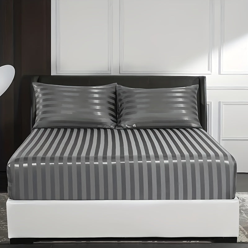 Bed with gray striped bedding and pillows in a bedroom setting