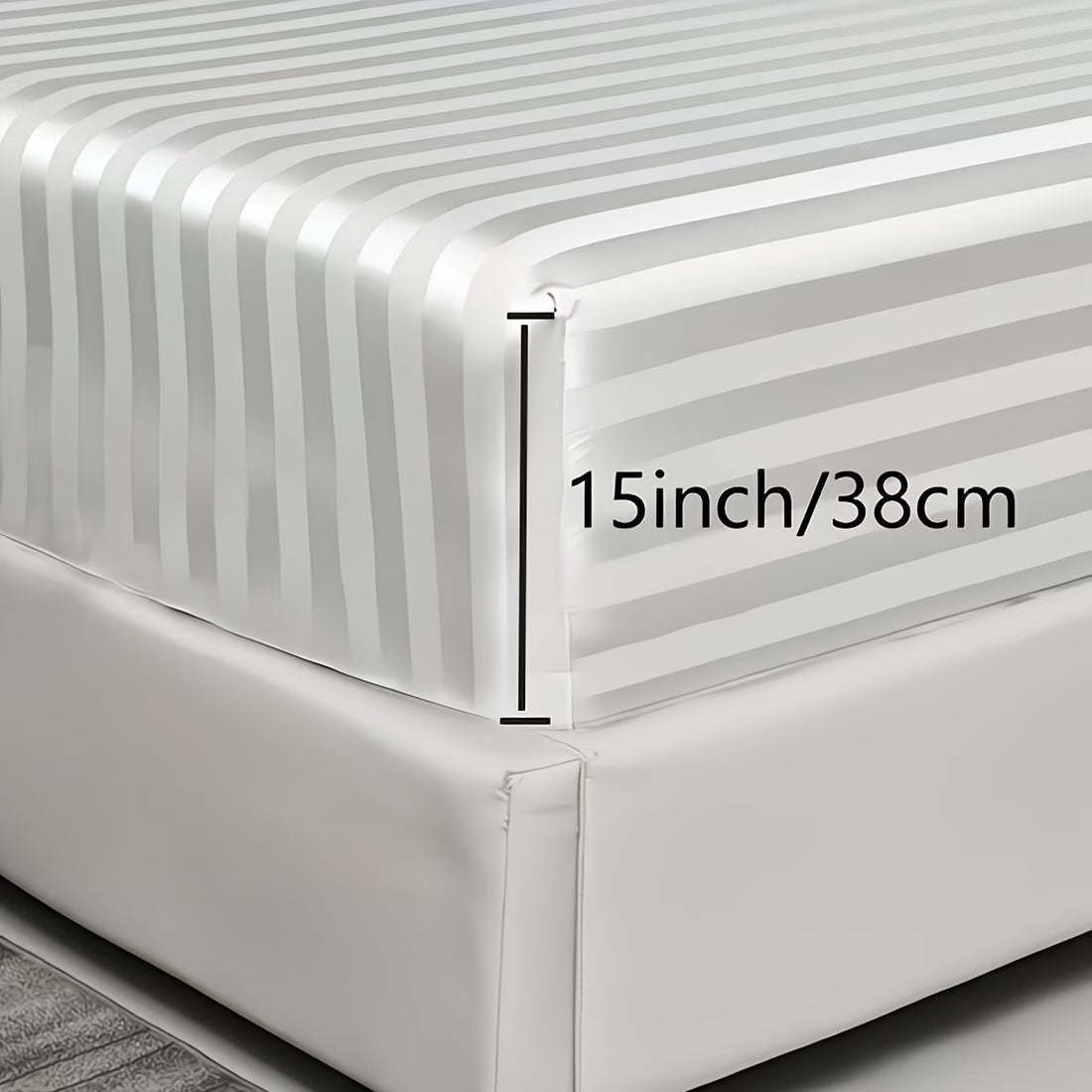 Clear bedskirt with gray stripes on a bed, showing measurement of 15 inches/38 cm.