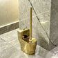 Gold toilet brush holder on a marble bathroom floor