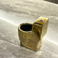 Gold-colored miniature toilet on a marble surface