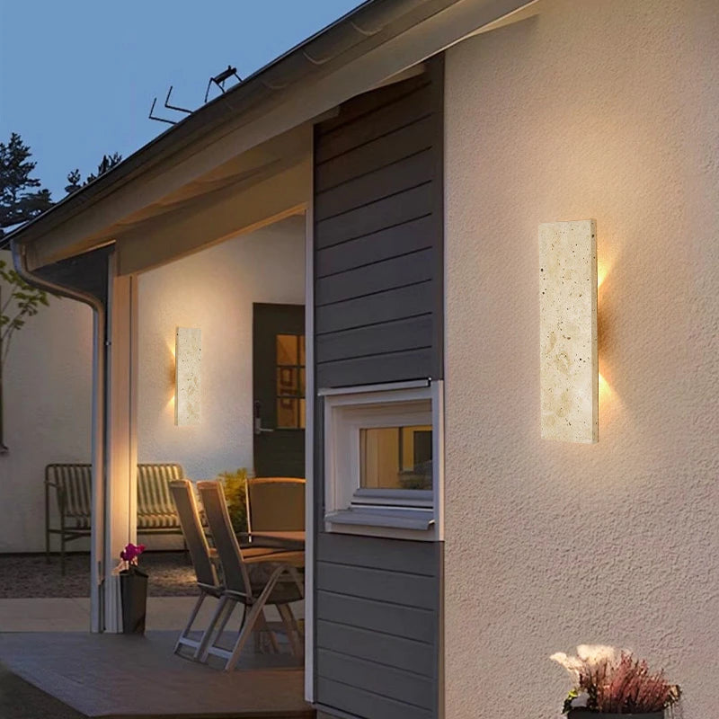 Modern outdoor setting with wall-mounted lights on a house exterior.