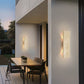 Modern outdoor setting with a dining table and chairs under wall-mounted lights.