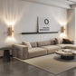 Modern living room with a beige sectional sofa, coffee table, and wall art.