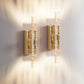 Two gold wall sconces on a white wall