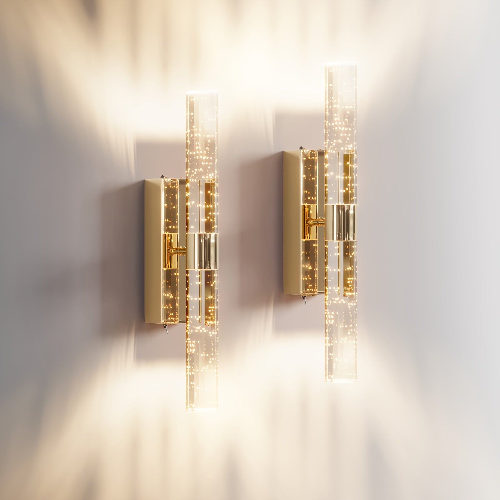 Two gold wall sconces on a white wall