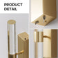 Gold wall sconce with clear glass shade on a white background