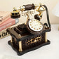 Vintage-style rotary phone with gold accents on a white surface