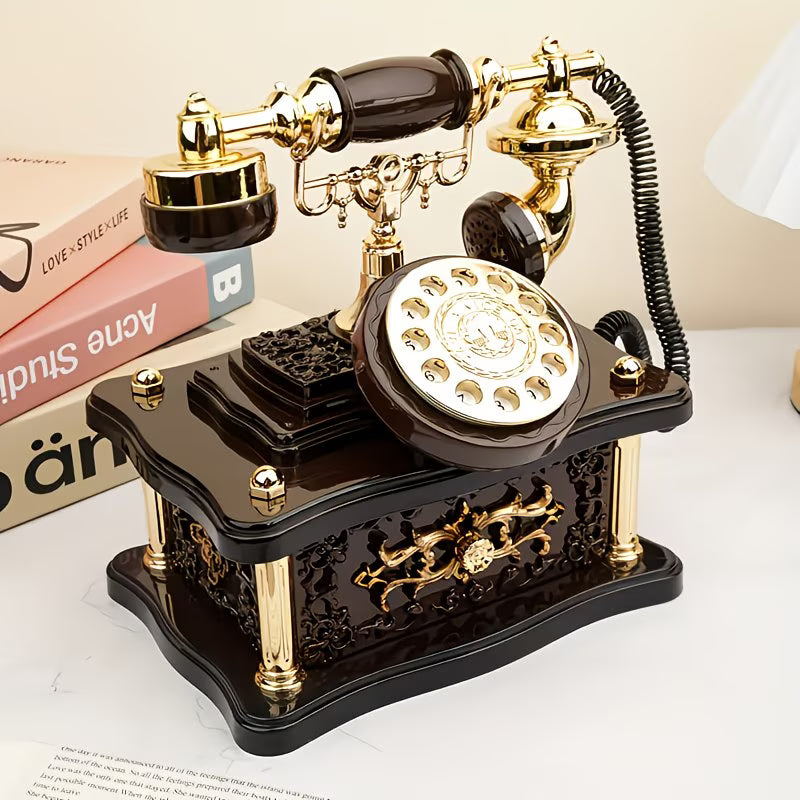 Vintage-style rotary phone with gold accents on a white surface
