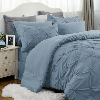 Blue textured bedding set on a bed with pillows and a nightstand.