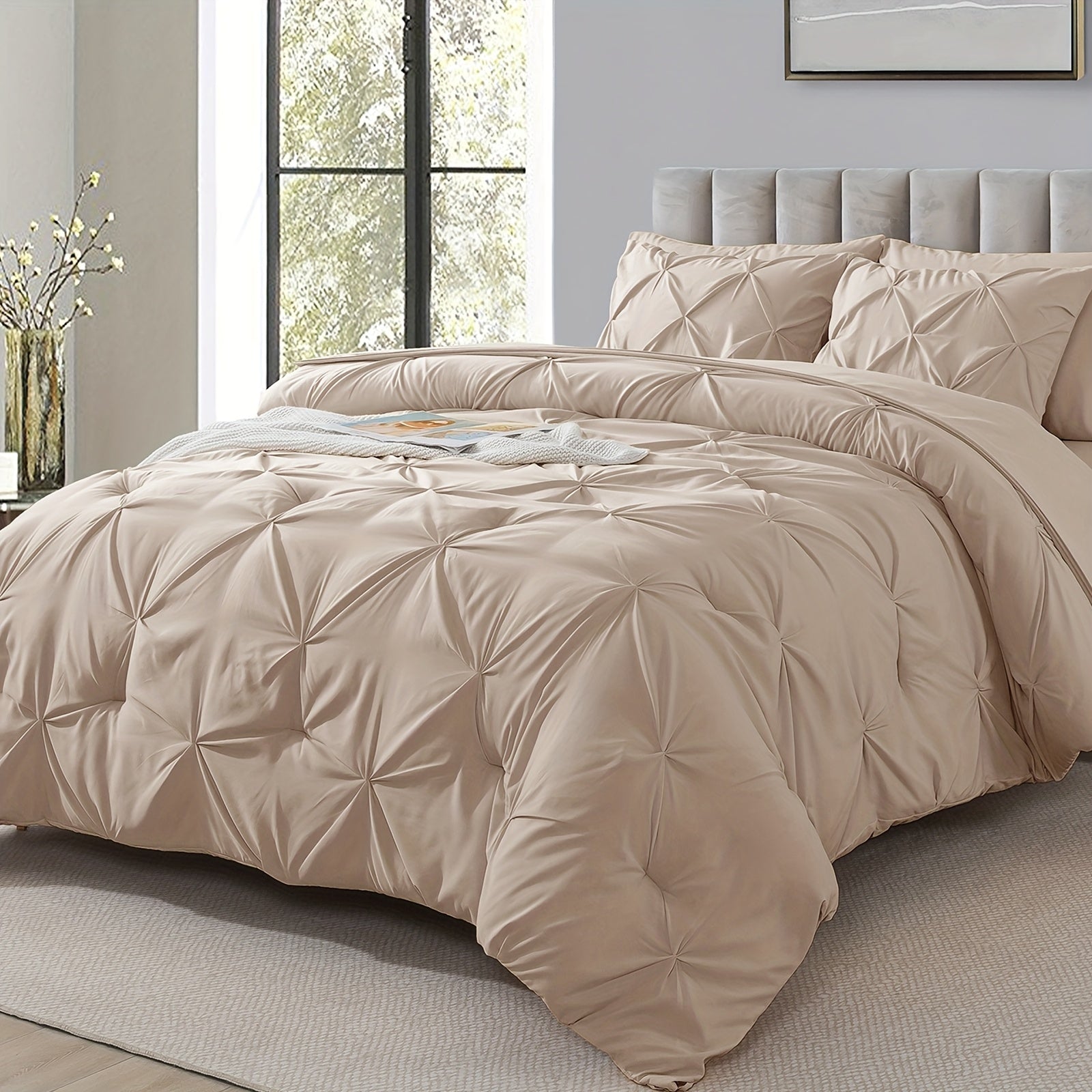 Beige comforter set on a bed in a bedroom with a large window.