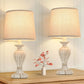 Two decorative table lamps with beige lampshades on a wooden surface.