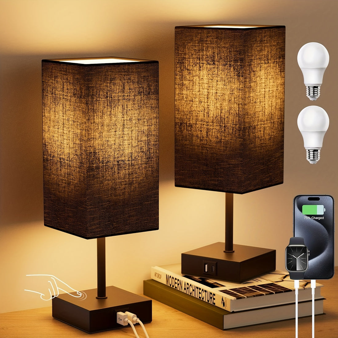 Two table lamps with brown fabric shades on a wooden surface, with light bulbs and charging devices displayed above.