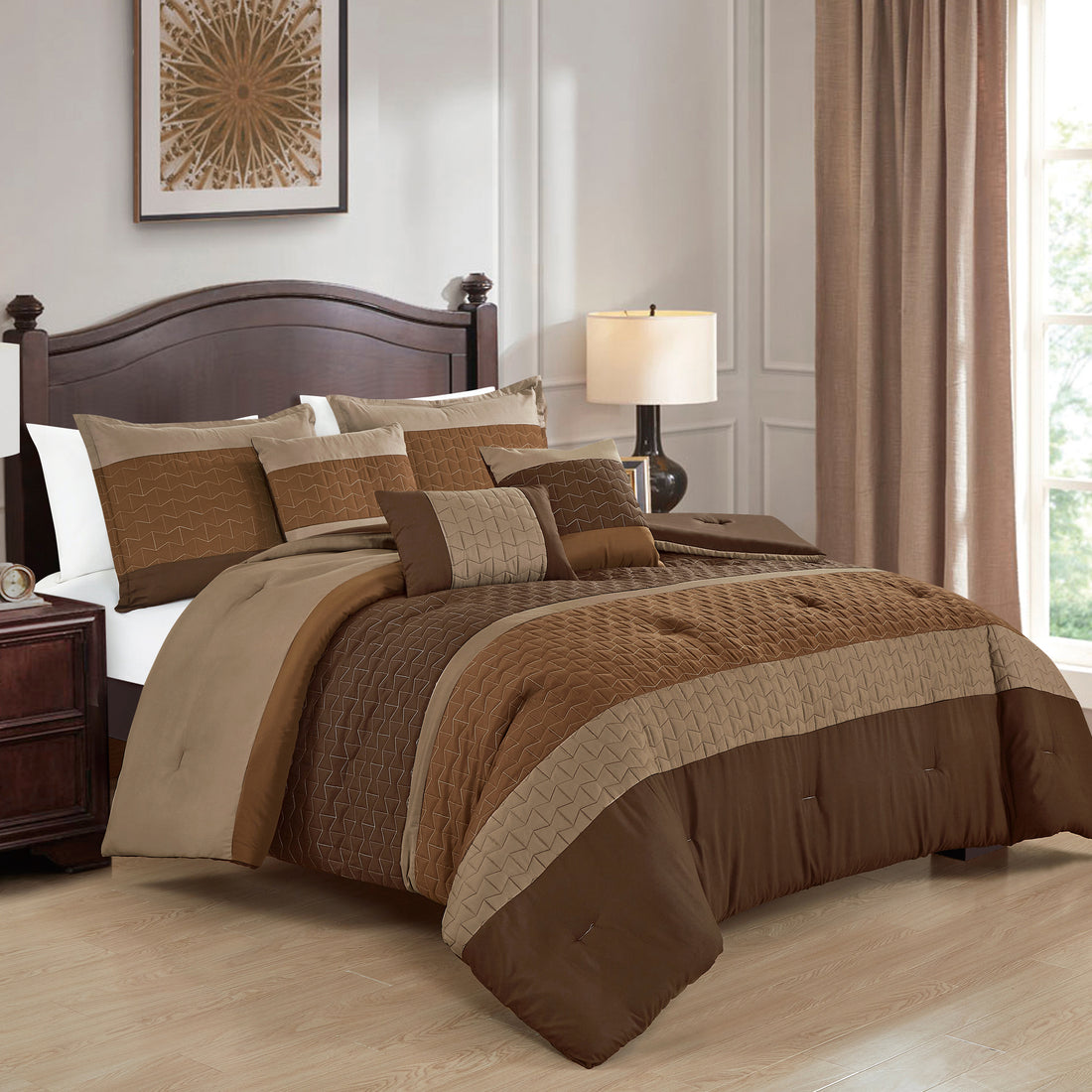 Bedroom with brown and beige comforter set on a bed, lamp, and framed artwork.