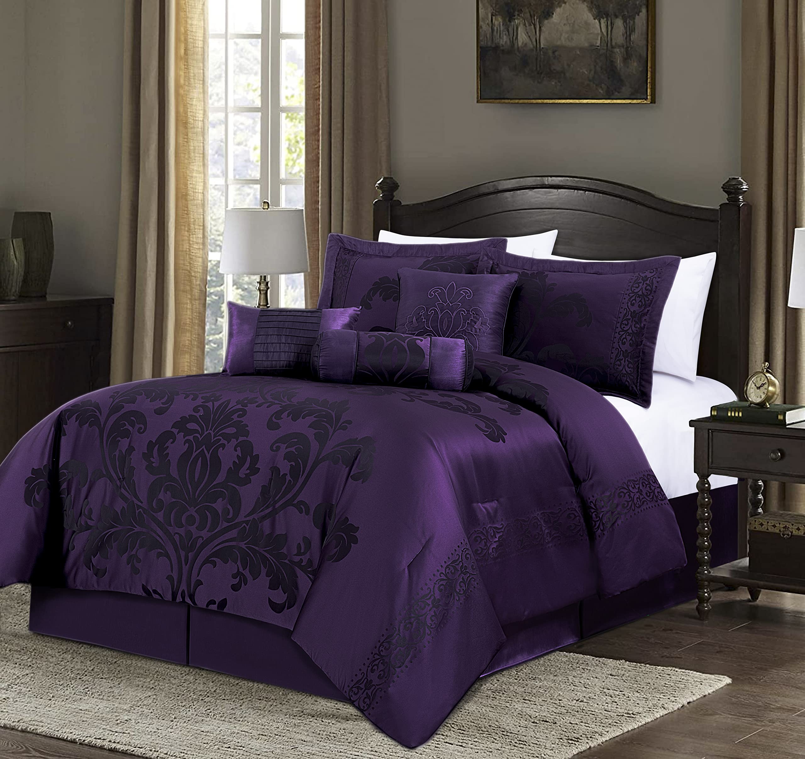 Purple damask bedding set on a bed in a bedroom with a lamp and decor.