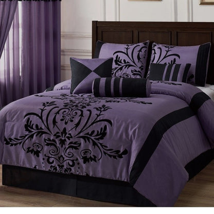 Purple and black damask patterned bedding set on a bed in a bedroom.