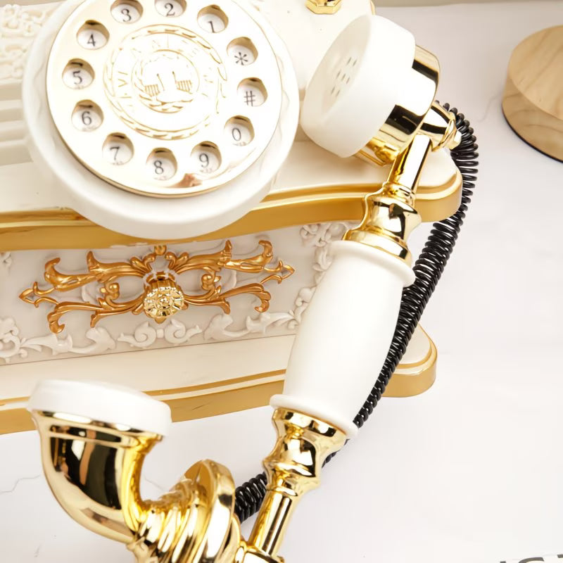 Vintage-style rotary phone with gold and white accents on a light background