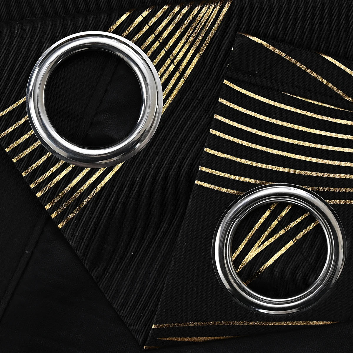 Two metallic rings on a black surface with gold geometric patterns