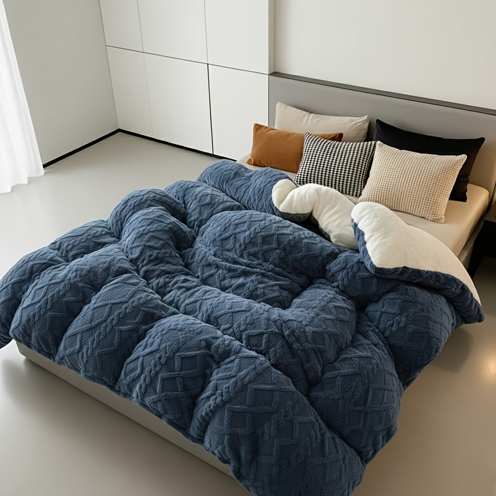 Blue textured comforter on a bed with pillows in a minimalistic room.