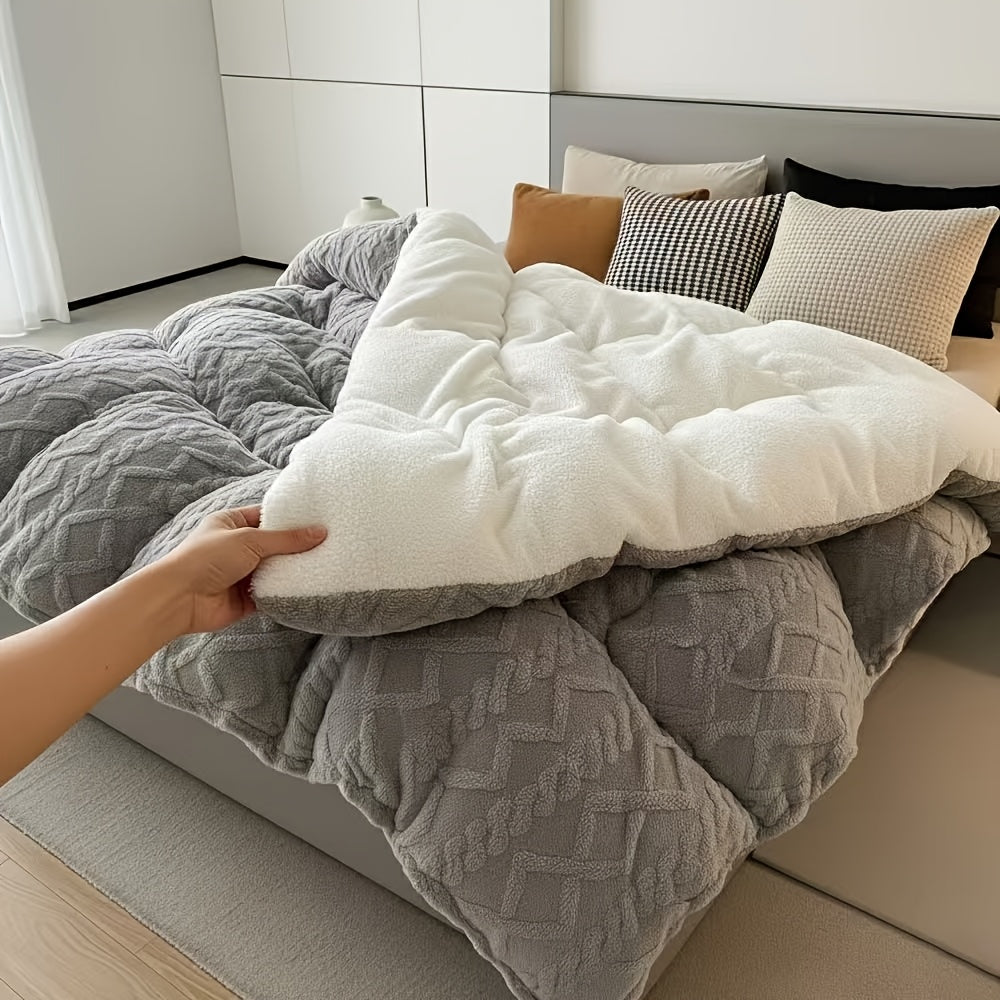 Person adjusting a white pillow on a bed with gray comforter