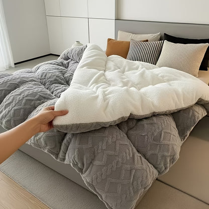 Person adjusting a white pillow on a bed with gray comforter