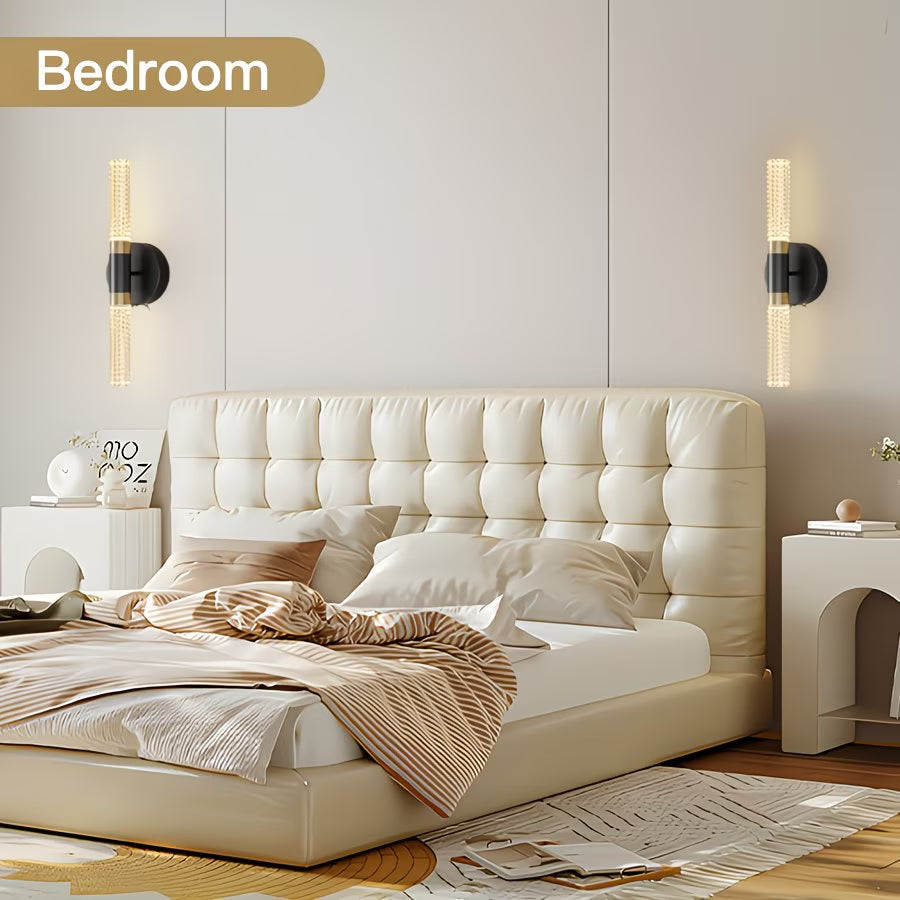 Beige upholstered bed in a modern bedroom with wall lights and decor.
